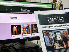 #ParaTodosVerem: A Imagem mostra um computador com o site do jornal-laboratório Lampião (UFOP) aberto na seção “Sobre”. Ao lado, há a versão impressa do jornal com a manchete em verde “Justiça pela metade não é justiça”. A capa destaca os 10 anos do desastre-crime de Fundão, com três fotos. A primeira de Seu Filomeno tocando junto da banda, a segunda sua casa antes do desastre-crime da mineração destruí-la em Bento Rodrigues, e a terceira, uma foto de Filomeno de costas, caminhando em direção às ruínas de sua casa.
