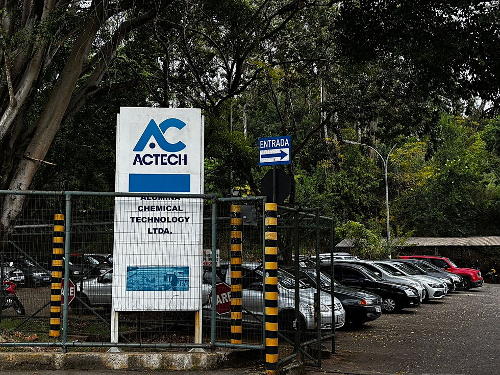 Portão de entrada da empresa ACTECH. Crédito: Júlia Quedevez e Maria Luiza Ribeiro. #ParaTodosVerem: Foto do portão de entrada da empresa. A imagem mostra o acesso principal às instalações da empresa, com o nome ACTECH identificado na estrutura de entrada.
