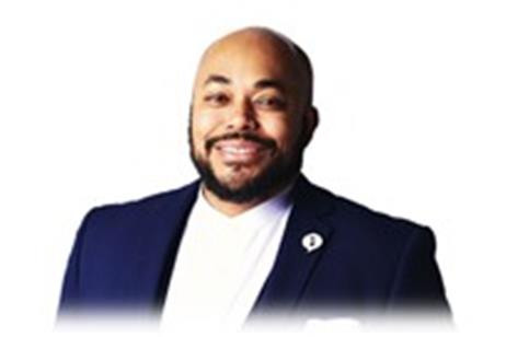 Black man smiling, in a suit.