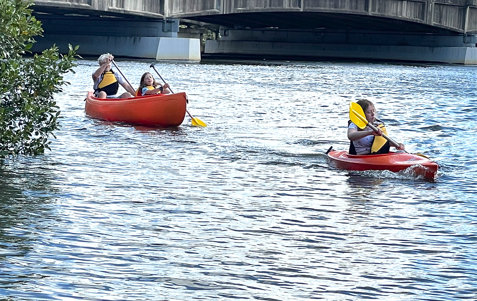 A famliy paddles a Sydney Rivers Canoe Hire canoe and kayak on the Cooks River in Tempe.