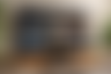 TV screen shows "Masterchef Canada" episode with two chefs, kitchen background. Menu below includes options like "Top Critic." Room has plants.