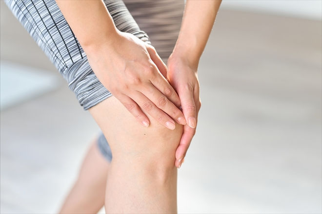 膝の痛みを両手で抑える