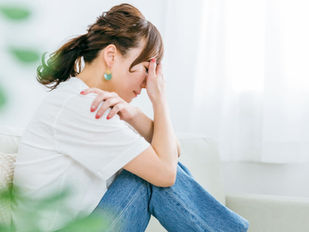 偏頭痛で頭を抱える女性