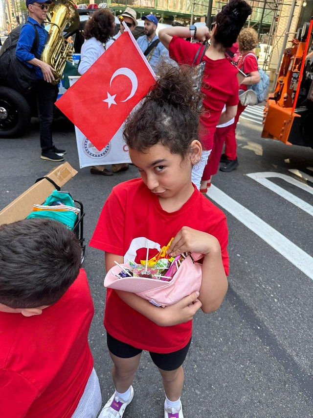 Child holding a Turkish flag at the Youth and Sports Day Parade.