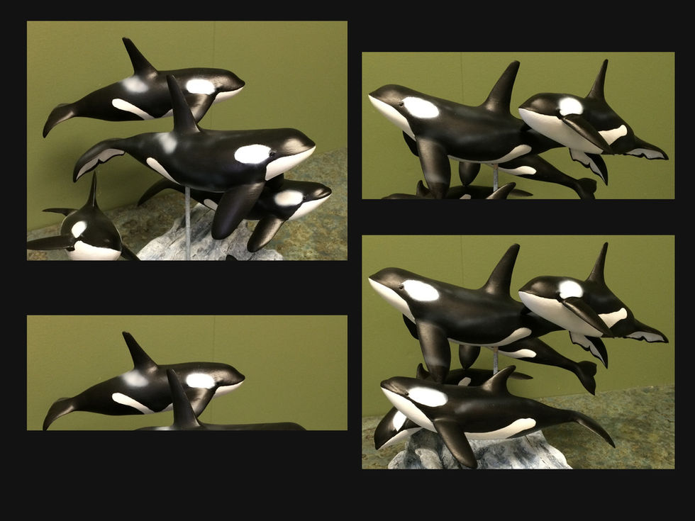 Orca family pod sculpture carved entirely from wood.