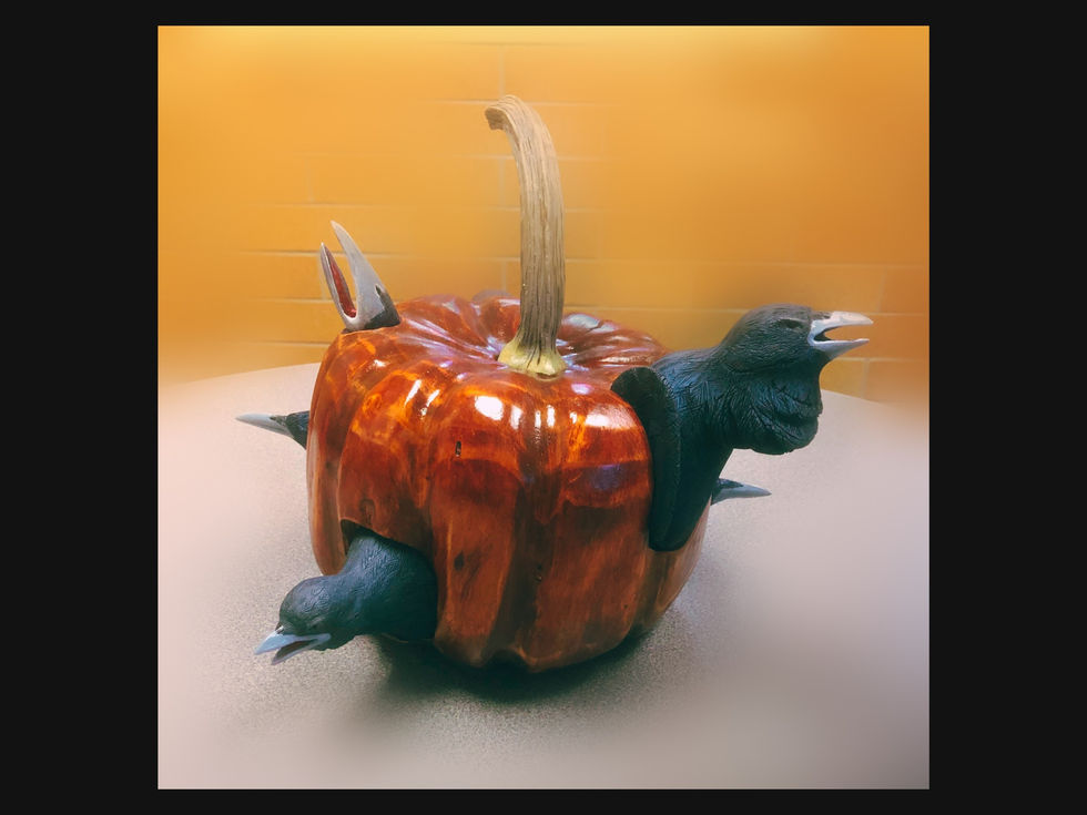 All-wood carving of several crows emerging from a pumpkin, fall harvest artwork.
