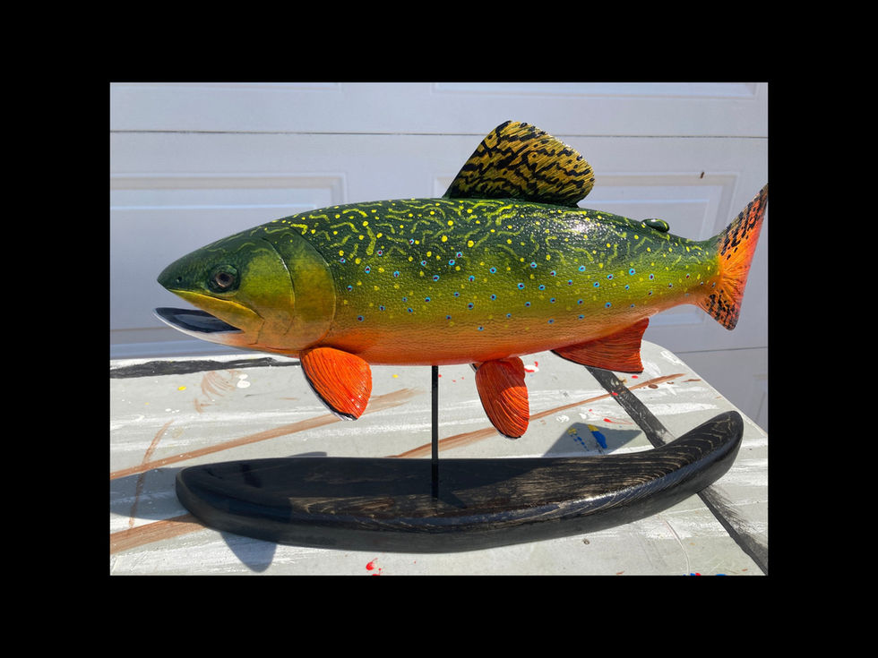 Brook trout wooden carving mounted on base with realistic coloration.