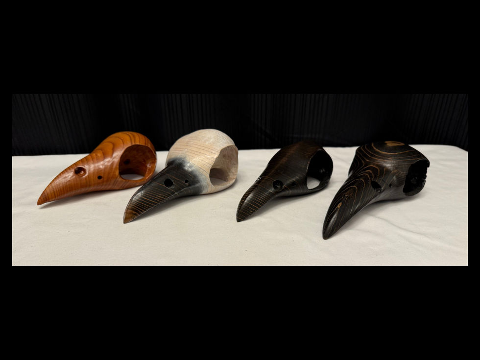 Artisan wooden raven skull carvings showing varied grain patterns and stain colours