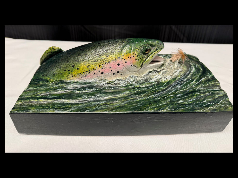 Detailed wood carving of a rainbow trout breaking the surface to strike a fishing fly