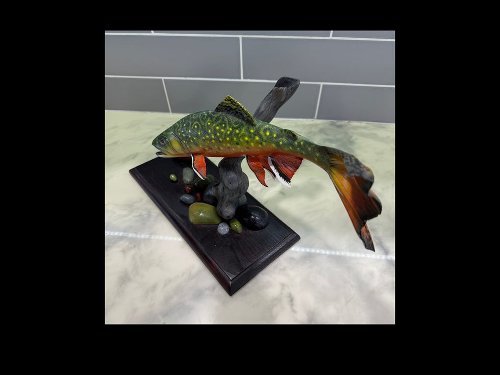 Close-up of carved brook trout head with painted markings and glass eye detail