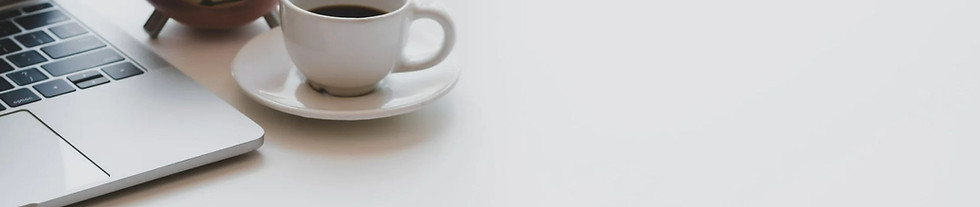 edge of laptop keyboard with a cup of coffee