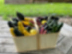 Closeup of two wooden baskets of zucchinis and okra.