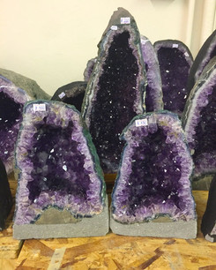 three U shaped amethyst geodes on a table