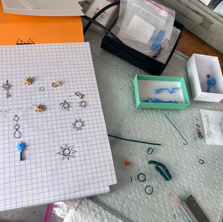 a desk with sketch book and various waxes and tools