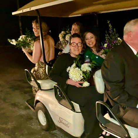 People riding on a golf cart shuttle.