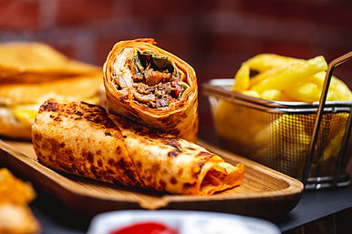 side-view-doner-with-grilled-chicken-greens-lettuce-tomato-french-fries-table.jpg