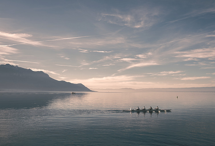 a group of people rowing a boat in the water