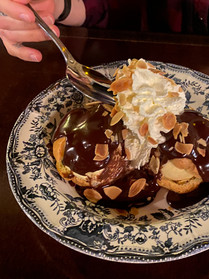 Homemade chocolate profiteroles, a decadent dessert on the menu at the Au Petit Marquis restaurant in Versailles