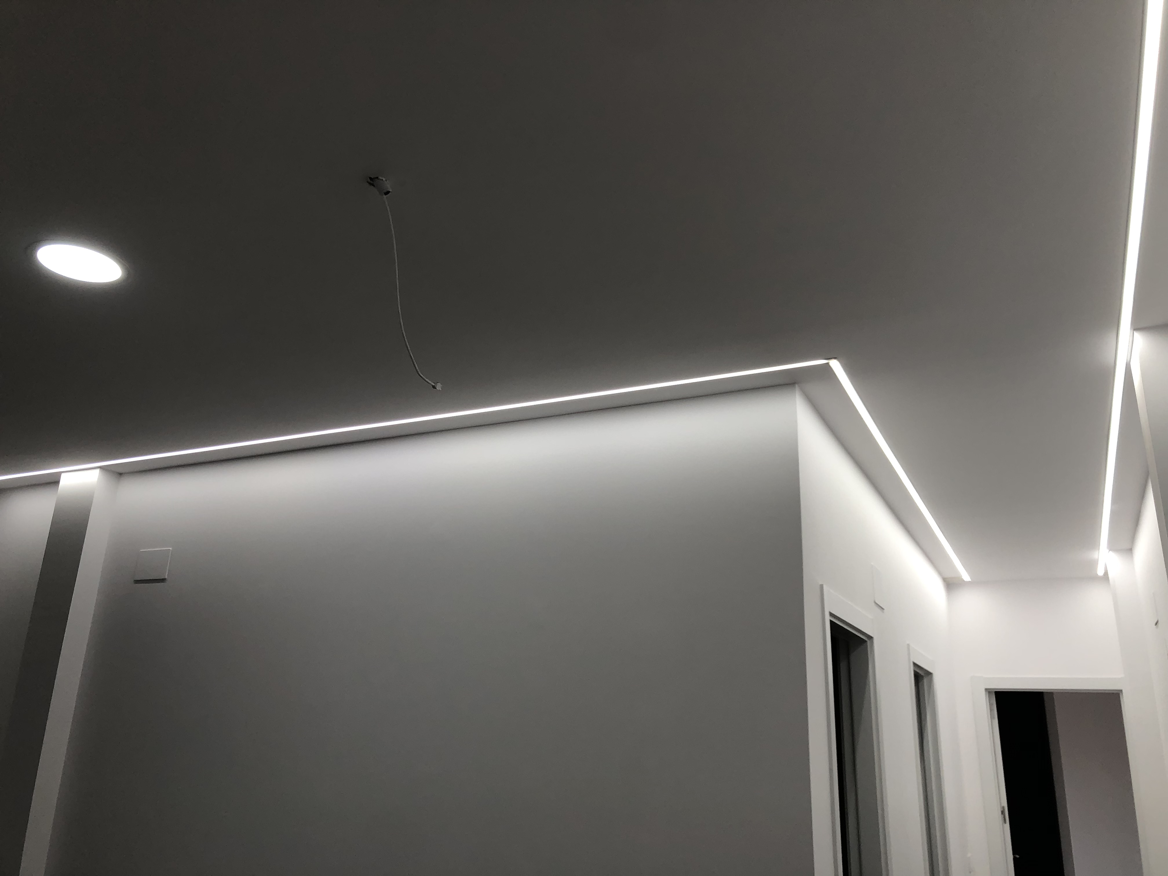 Detalle de iluminación LED perimetral y punto de luz en el techo