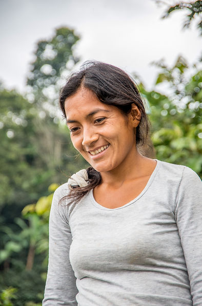 This image shows a women coffee producer in the field.