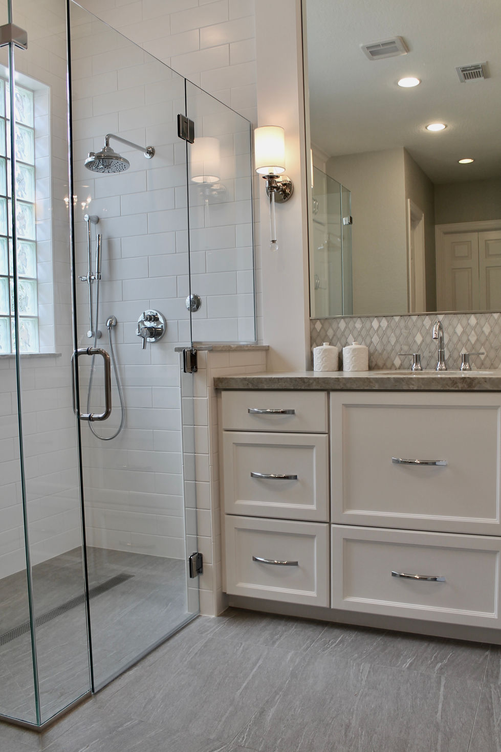 Freestanding Tub, Storage, White Cabinets, Hamper in Vanity, Mosaic Wall Tile, Polished Nickel Fixtures, Quartzite Countertops, Natural Stone Countertops, Large Format Floor Tile, Curbless Shower, Grab Bars, Hidden Shower Niche, Large Custom Mirrors, Sconces, Vanity, Make Up area, Storage, Drawers under Sink, Shower Body Sprayers