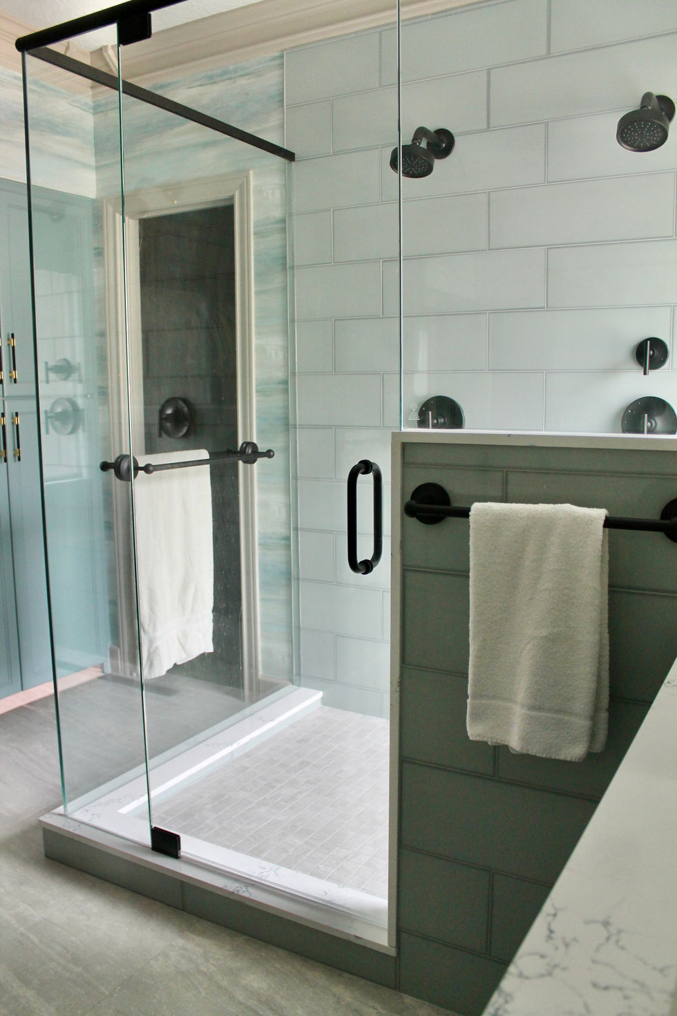 Blue Cabinets, Gold and Black Hardware, White Quartz Countertops, Large Format Floor Tile, Large Mirrors, Dual Shower, Bench, Wall Sconces