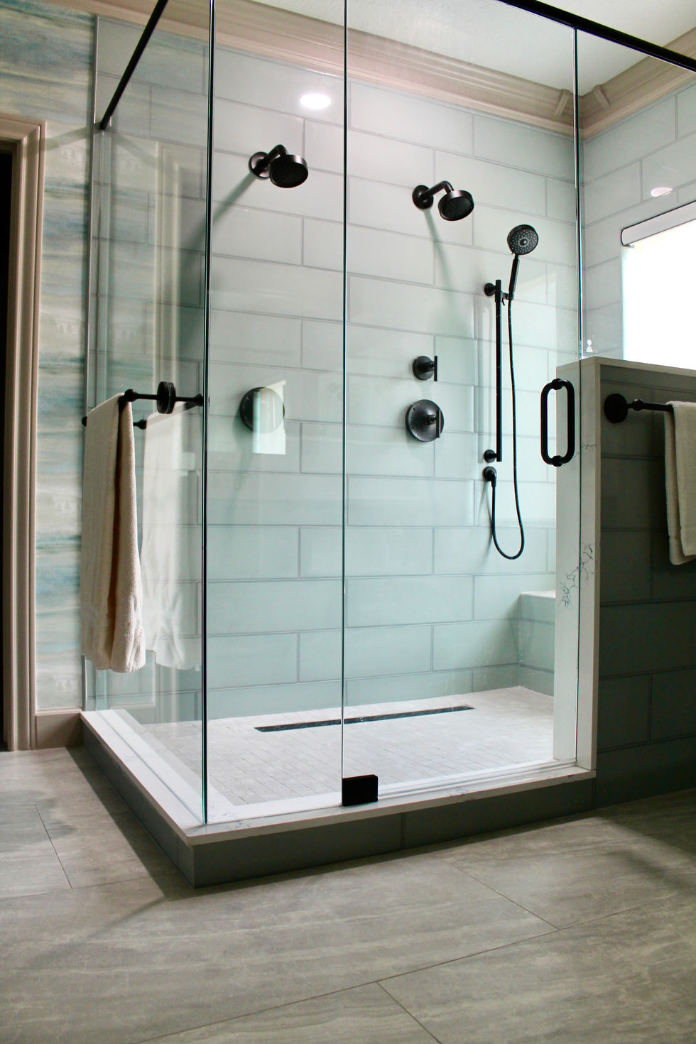 Blue Cabinets, Gold and Black Hardware, White Quartz Countertops, Large Format Floor Tile, Large Mirrors, Dual Shower, Bench, Wall Sconces
