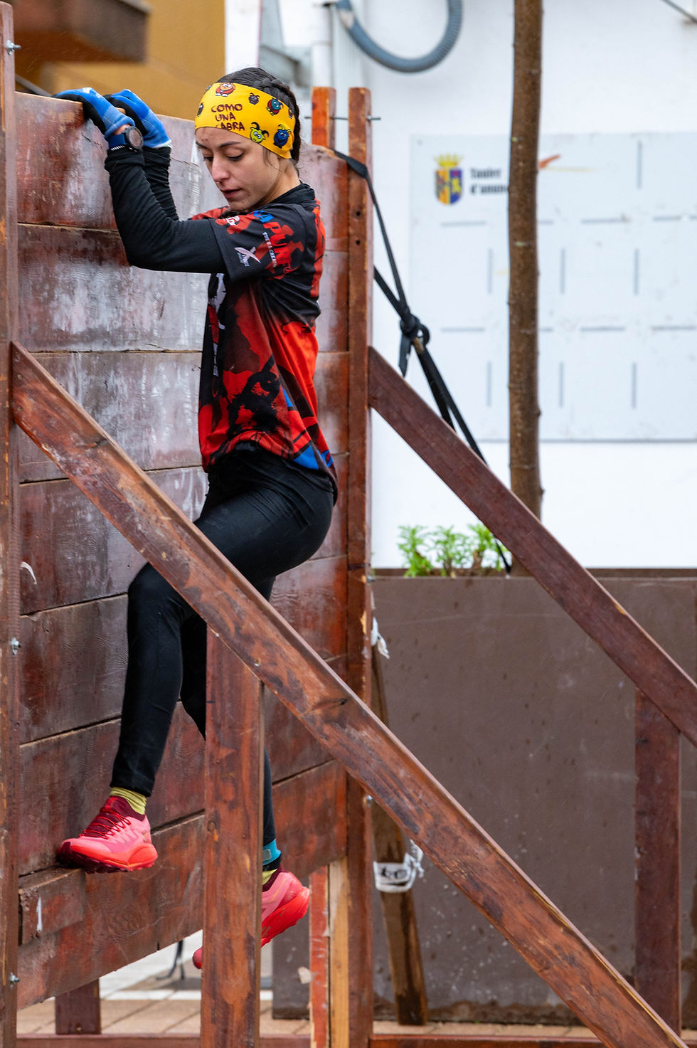 Corredor superando un muro en una carrera OCR.