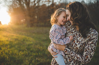 adult female holding female child laughing