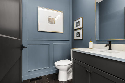 Britannia Blue powder room with feature walls and custom vanity with quartz countertop and black faucet and door hardware.