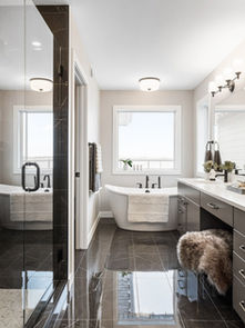 Luxury ensuite in Touchstone custom home with tile shower, soaker tub, dual vanity, tiled shower with bench and niche, and abundant sunlight