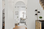 •	An elegant arched entryway leading from the foyer to the living room, adding a touch of sophistication to the space.