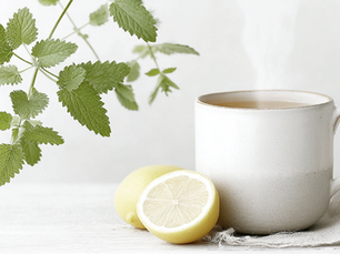 Fresh peppermint leaves steeping for a bloat-reducing brew beside a lemon wedge.