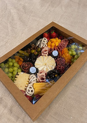 Premium Genussbox zum Liefern mit ausgewählten Käsesorten, Delikatessen, frischem Obst und hausmarinierten Antipasti