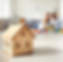 Wooden house model in focus with a family in the background, symbolizing estate planning and legacy protection.