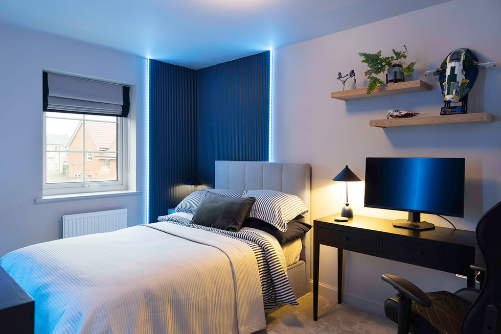 A teenage boy's bedroom with double bed, computer and panelling with LEDs