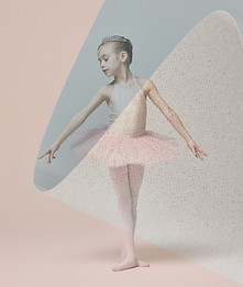 Young ballerina, wearing pink tutu and tiara, standing in elegant pose with arms outstretc