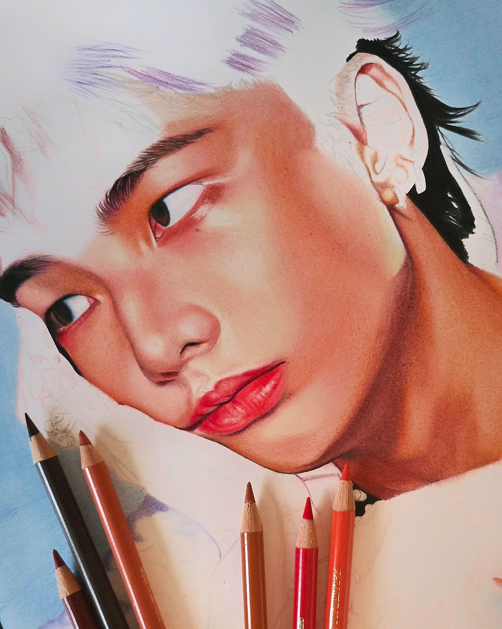 Portrait de Hyunjin en cours de réalisation aux crayons de couleur, avec travail détaillé sur la peau et les yeux, crayons visibles au premier plan.