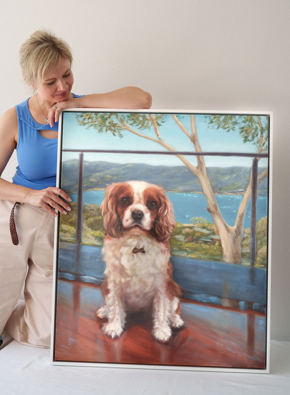 Elena Valerie holding Oil painting of a Blenheim Cavalier King Charles Spaniel named Maverick