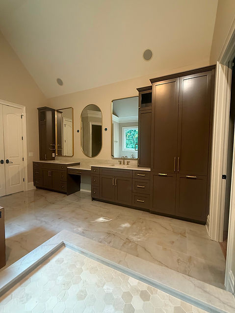 Luxury master bathroom with custom double vanities, floor-to-ceiling storage cabinetry, quartz countertops, and premium finishes for a functional, elegant design.