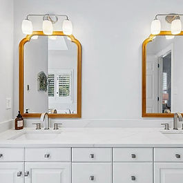 white updated bathroom with a double arched mirror