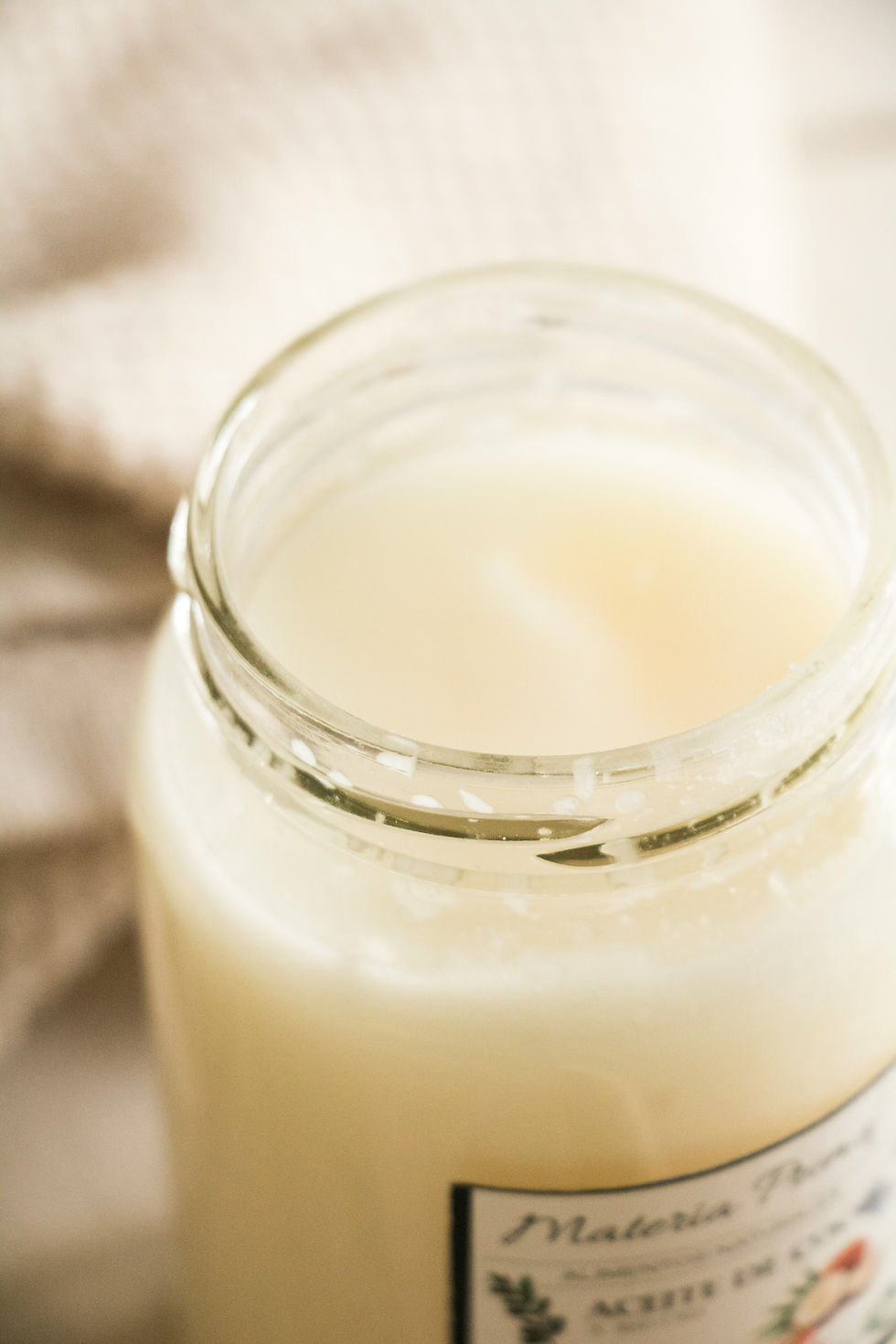 All-natural, non-GMO, organic raw cold-pressed coconut oil in a glass jar, perfect for armpit detox and DIY natural deodorant for toxin-free skincare.