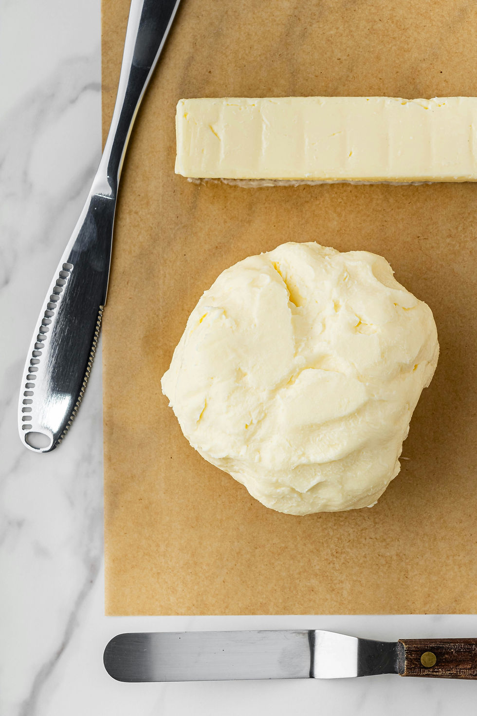Two batches of homemade butter—one shaped into a stick form and the other in a ball—showing the creamy texture and versatility of homemade butter.