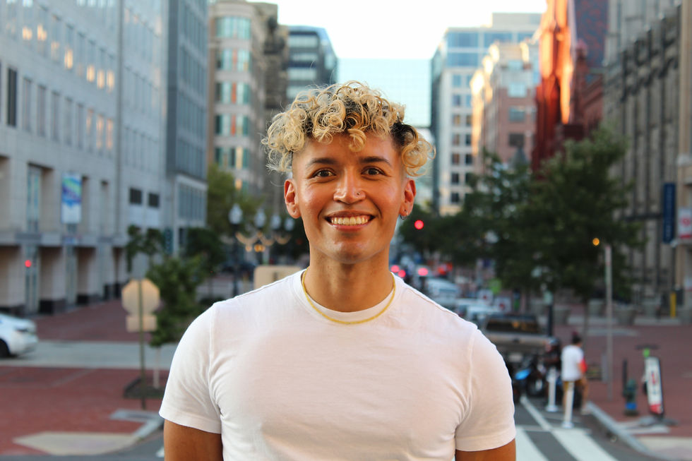 Smiling entrepreneur in a white shirt stands in front of city buildings. My Portfolio.