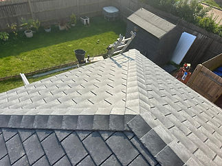 A rooftop with gray shingles in sunlight