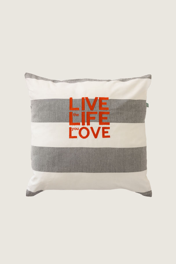 Strandkussen van Côté Zoute met de quote “Live Life Love”