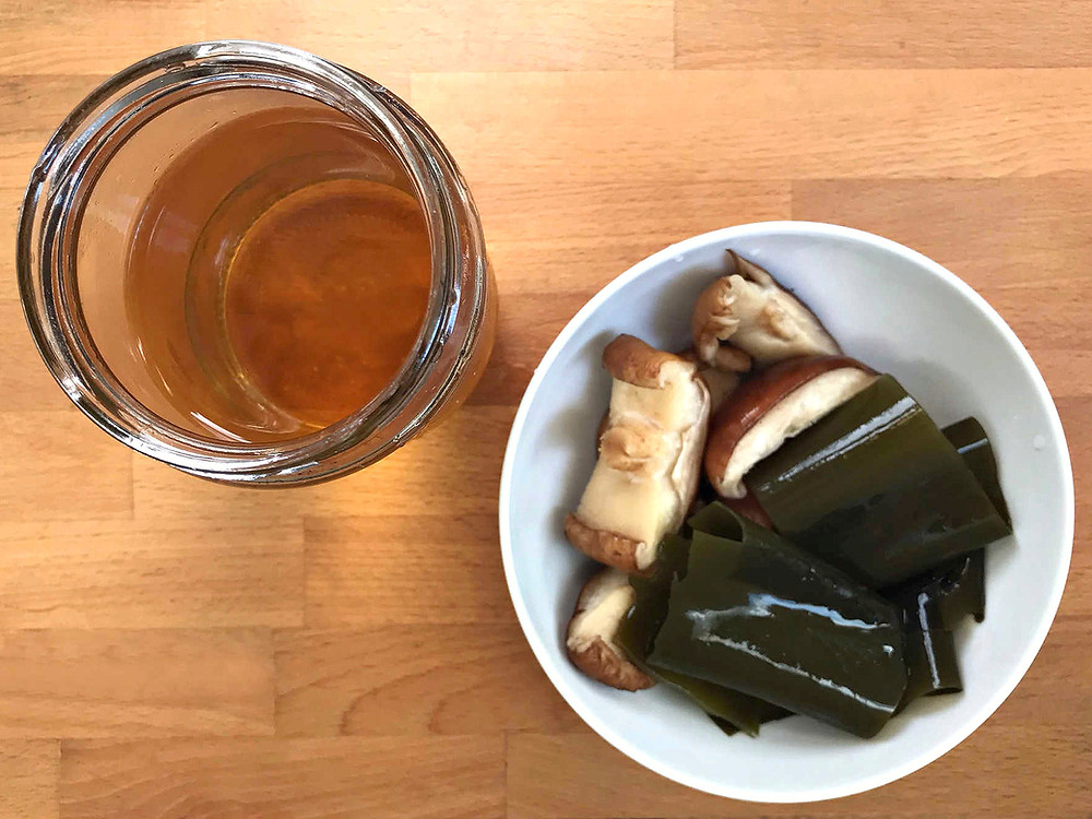 Jar of Vegan Dashi With Bowl of Shiitake Mushroom Pieces and Kombu
