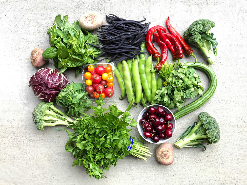 Fresh produce from farmers market tomatoes, beans, peppers, lettuce, broccoli, cherries, herbs