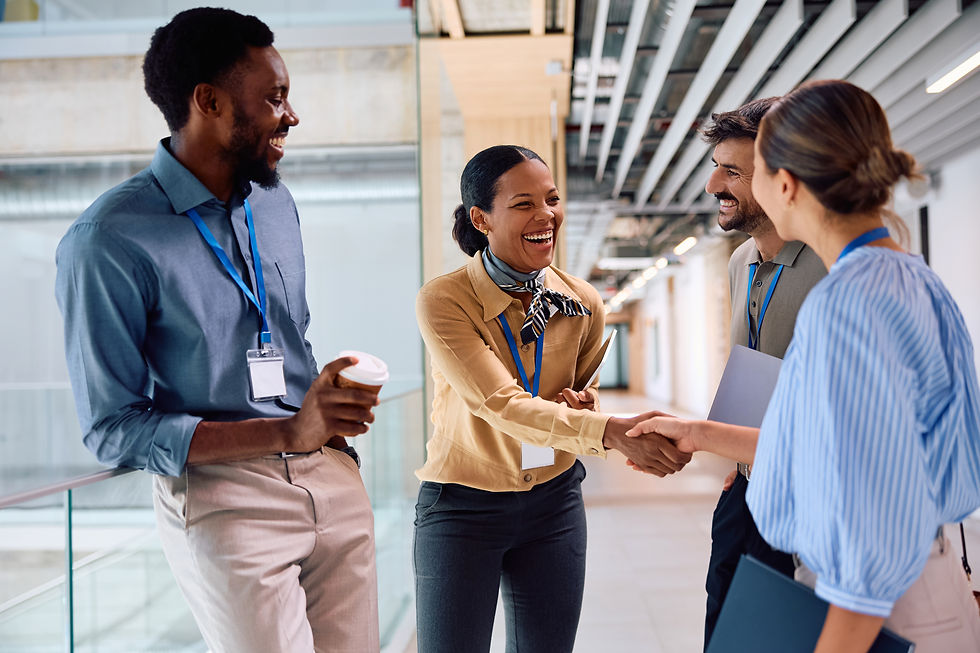 Happy female coworkers smile and shake hads in an office common area.