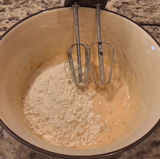In a separate bowl, mix the flour and baking powder. Gradually fold the dry ingredients into the wet mixture until the batter is smooth.